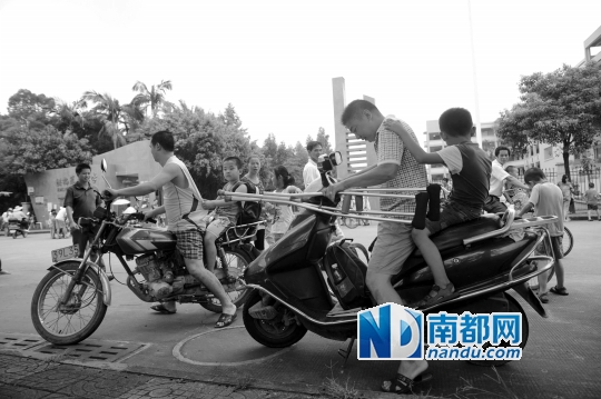 <p>因校車座位不夠，洪梅第二小學今年的新莞人新生不能坐校車，許多家長只能騎車接送孩子。南都記者劉在富攝<br /><br /></p>