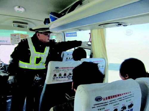 執(zhí)勤交警現(xiàn)場檢查客運車輛安全設(shè)施