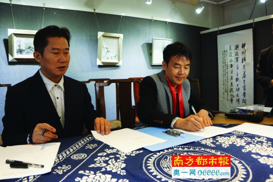 葉光榮(右)在設(shè)立葉光榮詩歌獎協(xié)議上鄭重地簽下自己的名字。通訊員 周崇賢 攝